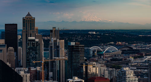 Aerial view of buildings in city against cloudy sky