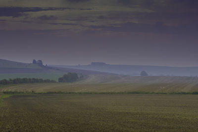 Scenic view of field against sky during foggy weather