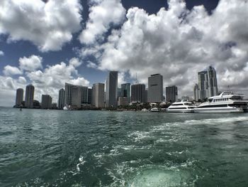 View of cityscape against cloudy sky