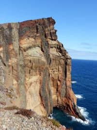 Rock formations in sea against clear sky