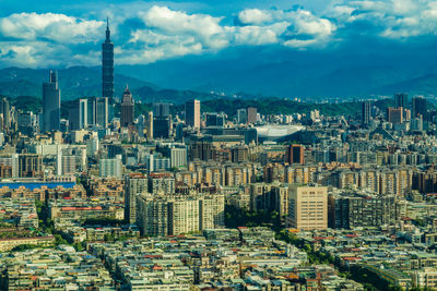 Aerial view of buildings in city against sky