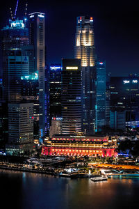 Illuminated buildings in city against sky at night