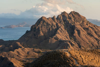 Scenic view of mountain by sea against sky