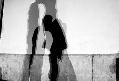 Shadow of couple kissing against wall