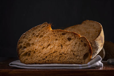 Close-up of bread on cutting board against black background