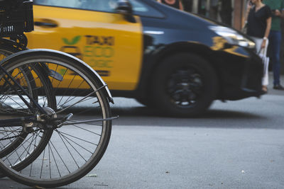 Bicycle and taxi on road in city