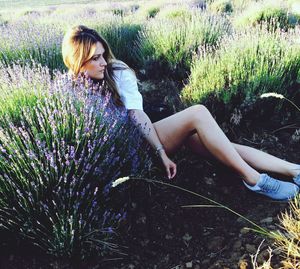 Young woman with flowers on field