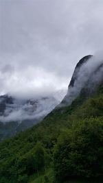 Scenic view of mountain against cloudy sky in foggy weather