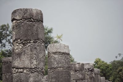 Low angle view of old stone wall against clear sky