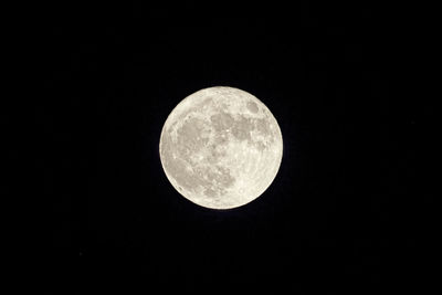 Low angle view of full moon against clear sky at night