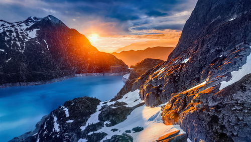 Scenic view of snowcapped mountains against sky during sunset