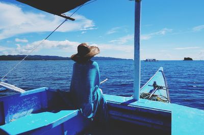 Man standing by sea against blue sky