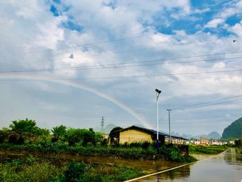 Scenic view of rainbow over plants against sky