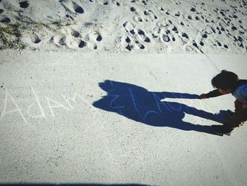 Shadow of man standing on sand at beach
