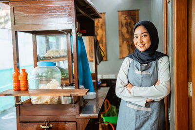 Portrait of smiling young woman standing in workshop