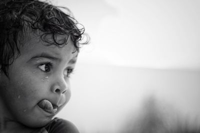 Close-up of wet boy sticking out tongue during rainy season