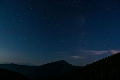 Scenic view of silhouette mountains against sky at night