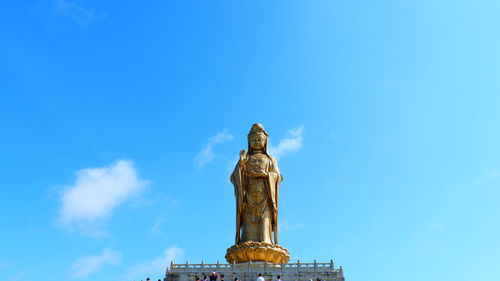 Low angle view of statue against blue sky