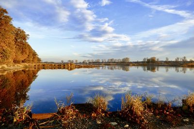 Scenic view of lake by buildings against sky