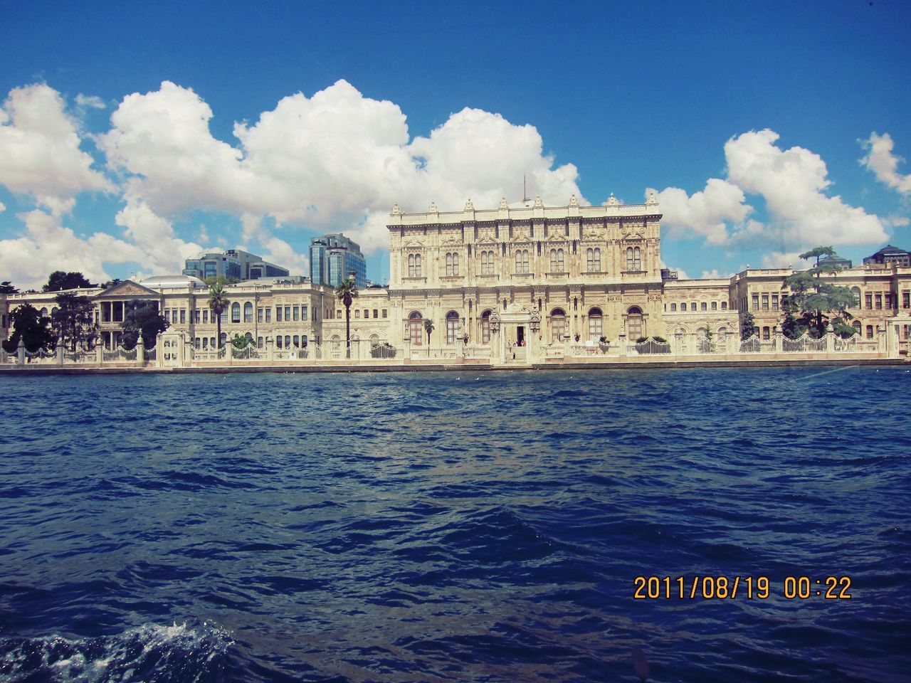 architecture, water, built structure, building exterior, waterfront, sky, text, cloud - sky, blue, travel destinations, sea, western script, famous place, travel, cloud, tourism, day, nautical vessel, transportation, rippled