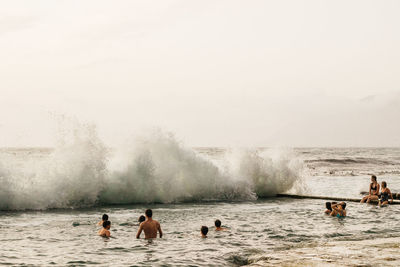 People enjoying in sea against sky