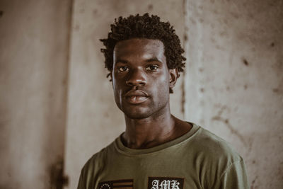 Portrait of young man standing against wall