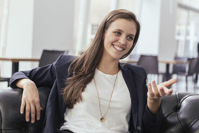 Portrait of smiling young business woman talking to somebody