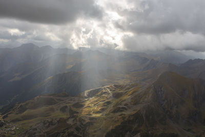 Sunbeams passing clouds and are reflected in the green mountains from the lentilla peak in france