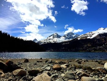 Scenic view of snowcapped mountains by sea against sky