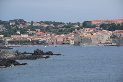 Townscape by sea against clear sky