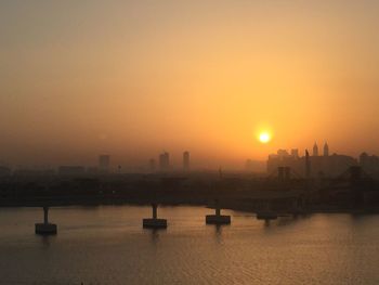 View of city at waterfront during sunset