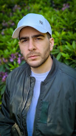 Portrait of young man standing against plants