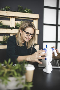 Portrait of young woman using smart phone on table