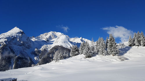 Scenic view of snowcapped mountains against blue sky