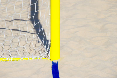 Close-up of yellow umbrella on sand