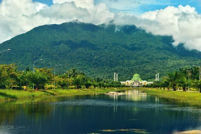 Scenic view of lake by buildings against sky