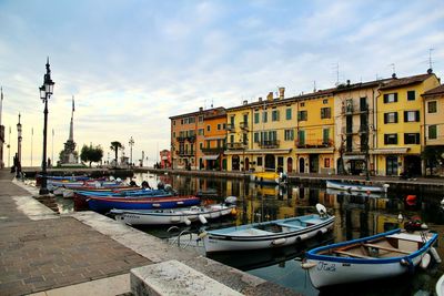 Boats moored on lake garda against sky