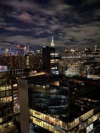 Illuminated buildings in city against sky at night