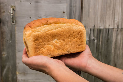 Cropped hands holding loaf of bread