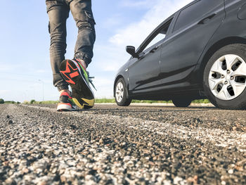 Low section of man walking on road