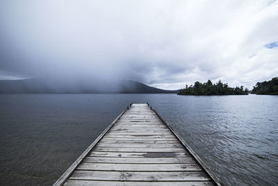 Pier over lake against sky