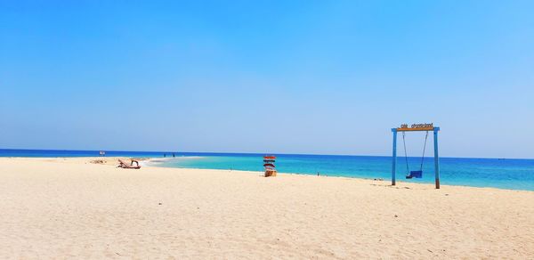 Scenic view of beach against blue sky