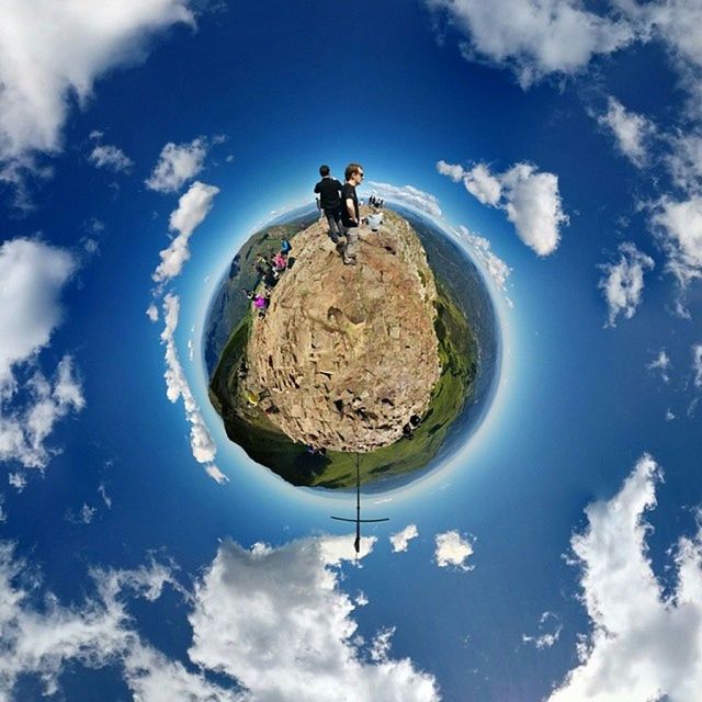 sky, cloud - sky, low angle view, blue, cloud, tranquility, nature, leisure activity, day, tranquil scene, cloudy, beauty in nature, scenics, lifestyles, rock - object, outdoors, sunlight, rock formation