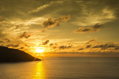 Scenic view of sea against dramatic sky during sunset