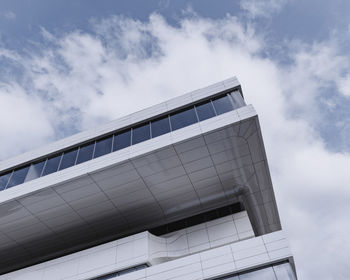Low angle view of modern building against cloudy sky