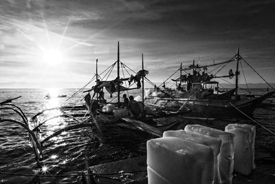 People fishing in sea against sky