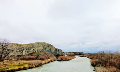 Scenic view of land and sea against sky