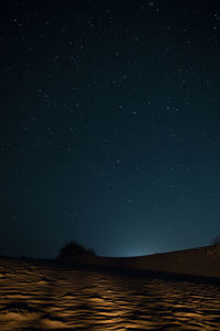 Scenic view of sand in desert against sky at night