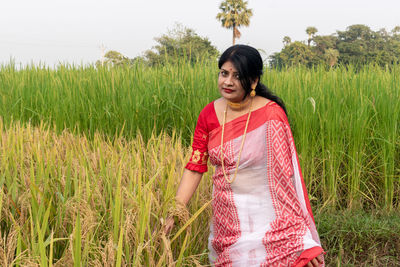 Portrait of young woman standing on field