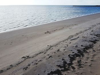 Close-up of sand on beach against clear sky